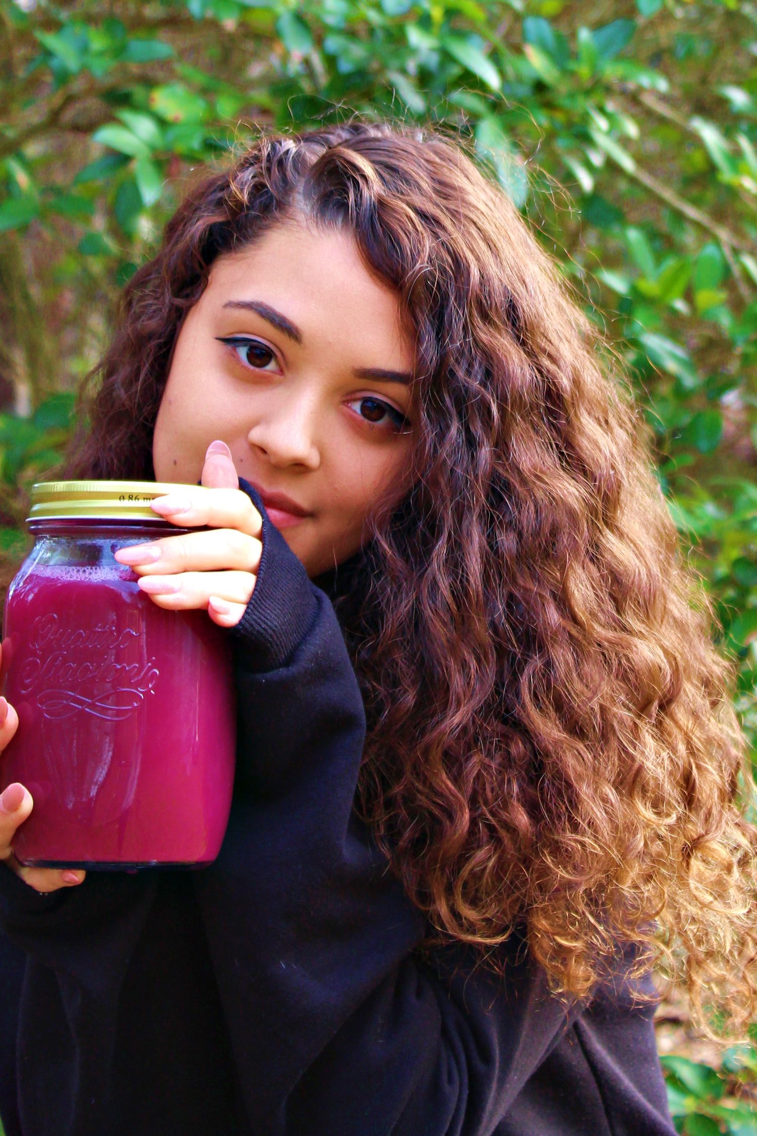 Kayla Dupoux outdoors holding a jar of juice